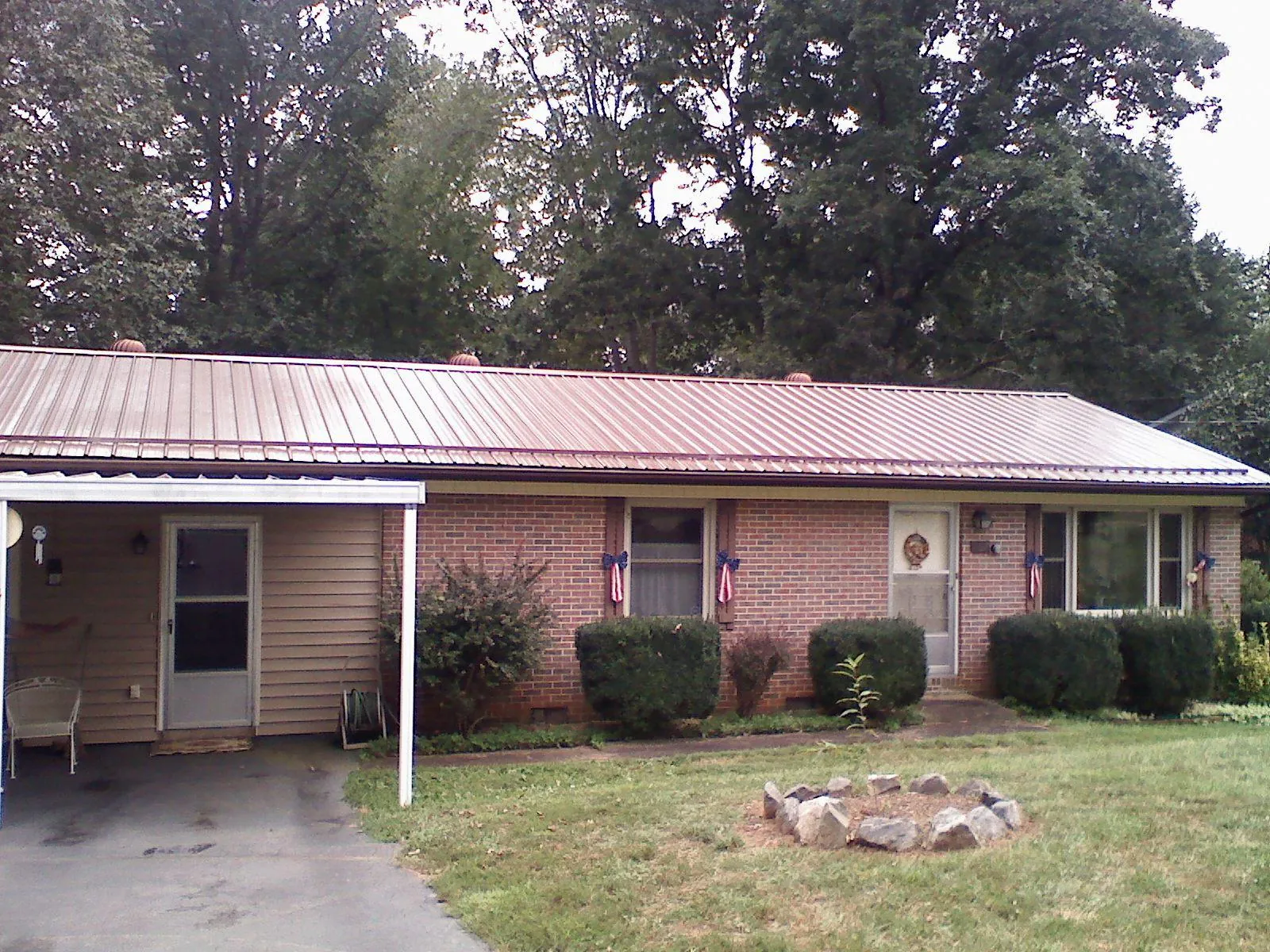 Bronze metal roof and carport on a brick ranch home — Roof Repair work by our crew in Morris